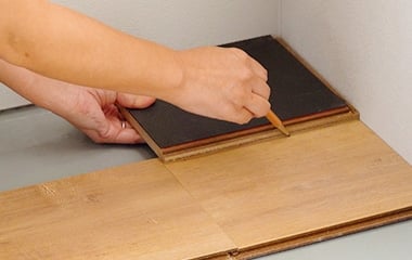 巾定規を裏返して仮敷きした床材の上に置く