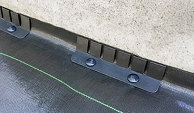 防草シートのキワをキワ押えプレートで押さえている施工例