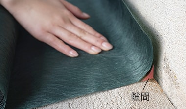 硬い防草シートが壁に沿わず反り上がっている様子